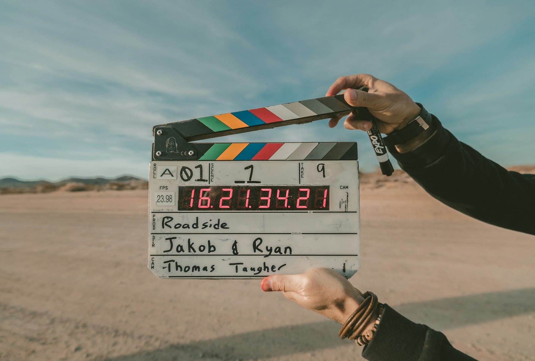 A film clapperboard held up against a desert backdrop